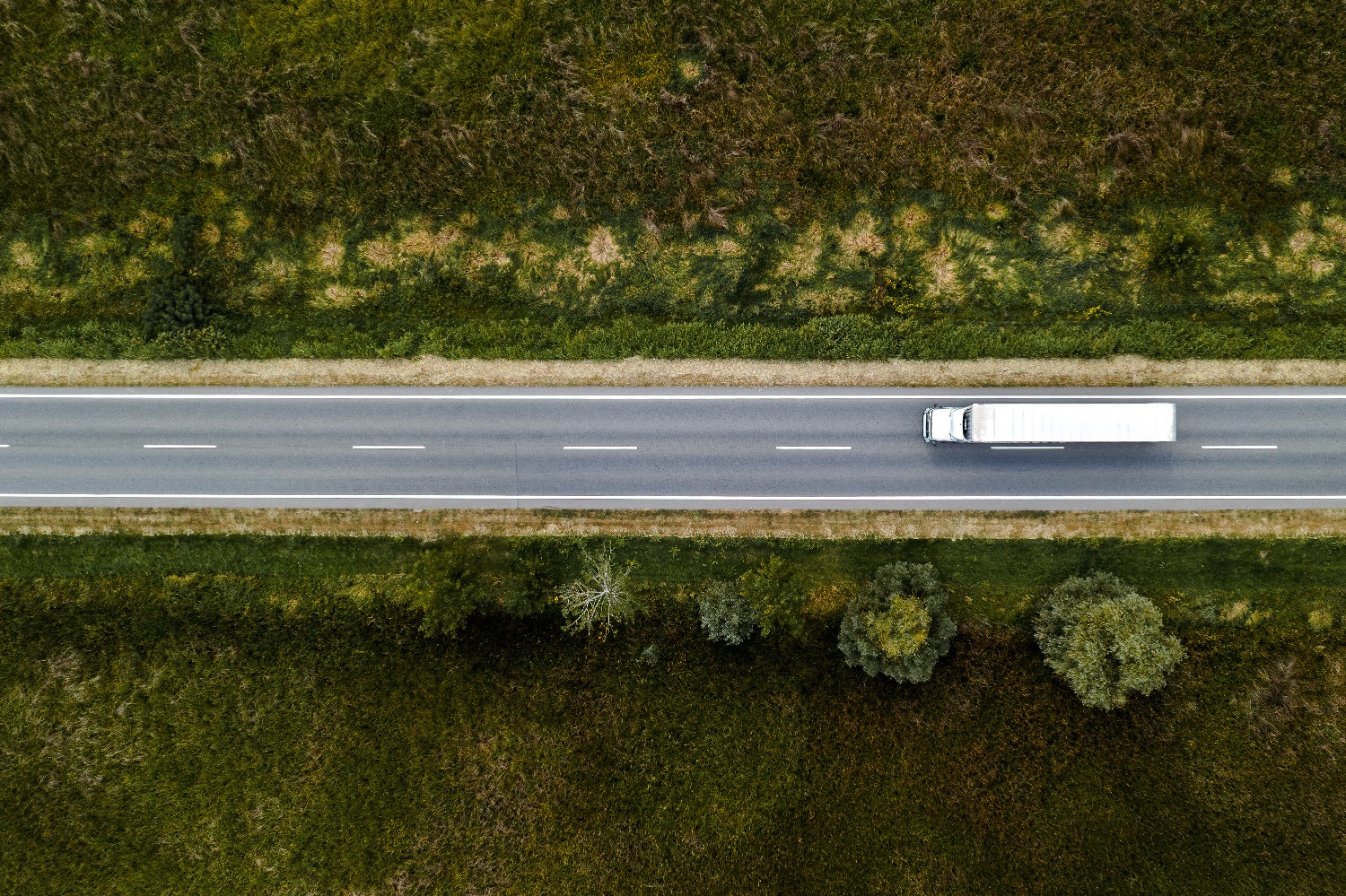 Dronebilde av en hvit trailerl som leverer Mekonomens varer rundt i landet